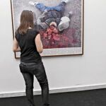 Una visitante observa el Googlegrama de Joan Fontcuberta en el que muestra una víctima de Irak
