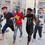 Un grupo de rebeldes libios detiene a un hombre, identificado como mercenario de las fuerzas de Gadafi, durante una batalla en Trípoli