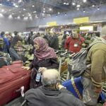 Varios pasajeros esperan a embarcar en un vuelo, ayer, en el saturado aeropuerto de El Cairo