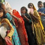 Niños paquistaníes hacen cola para recibir comida en un campo de refugiados en Nowshera, Pakistán