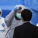 Un especialista mide la radiactividad de un japonés en uno de los controles