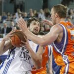 El base del Real Madrid Sergio Llull (i) entra a canasta ante el alero serbio del Power Electronics