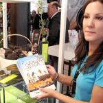 Una joven muestra folletos sobre el turismo gastronómico de Soria