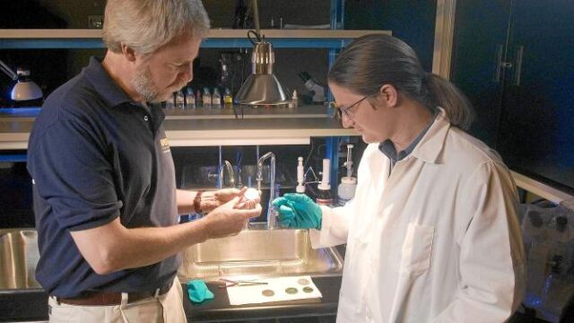 Stemm (izda.), en la sede de su empresa, examinando una moneda del barco