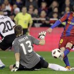 El delantero argentino del F. C. Barcelona, Leo Messi (d), intenta batir al guardameta del Valencia, Vicente Guaita (c)