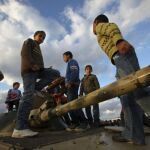 Varios niños juegan encaramados a un tanque en la ciudad de Benghasi