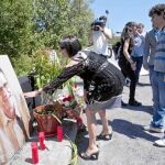 La viuda y sus dos hijos depositan unas flores en el lugar del asesinato