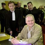 Illich Ramírez Sánchez, «El Chacal», flanqueado por su abogado y un policía en 2000. A la izquierda, cartel de la película «Carlos El Chacal», dirigida por Oliver Assayas. Abajo, Gadafi, patrocinador del terrorismo internacional