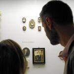Dos visitantes observan una de las vitrinas