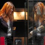 Una mujer contempla un busto que se exhibe en la exposición