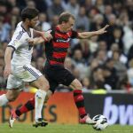 Michael Krohn-Dehli (d) intenta marcharse del centrocampista del Real Madrid Xabi Alonso (i),