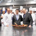 Alberto y Cándido López cortan un cochinillo en la apertura del II Curso Superior de Ayudante de Cocina