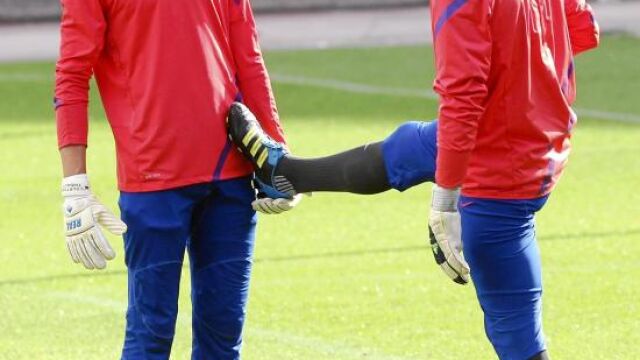 El meta belga Courtois y su compañero Joel hacen estiramientos en un entrenamiento del Atlético de Madrid