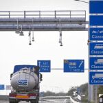 Un camión pasa por uno de los arcos de identificación automática de vehículos para el cobro de peaje en la A22, que une España y Portugal