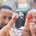 Dos electores egipcios muestras con satisfacción la prueba del voto