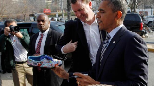 Obama firma en un zapatilla a un seguidor en Chicago