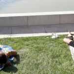 Tres jóvenes tomando el sol, ayer, en el madrileño parque de El Retiro