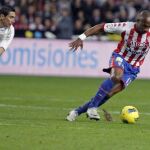 El defensa francés del Sporting de Gijón, Gregory Arnolin (d), controla la pelota ante la presión del delantero argentino del Real Madrid, Ángel di María
