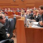 El presidente Herrera conversa con el portavoz popular, Carlos Fernández carriedo, ayer en las Cortes