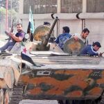 Miembros del Ejército Libre de Siria, ayer, con un tanque capturado en la provincia de Idlib