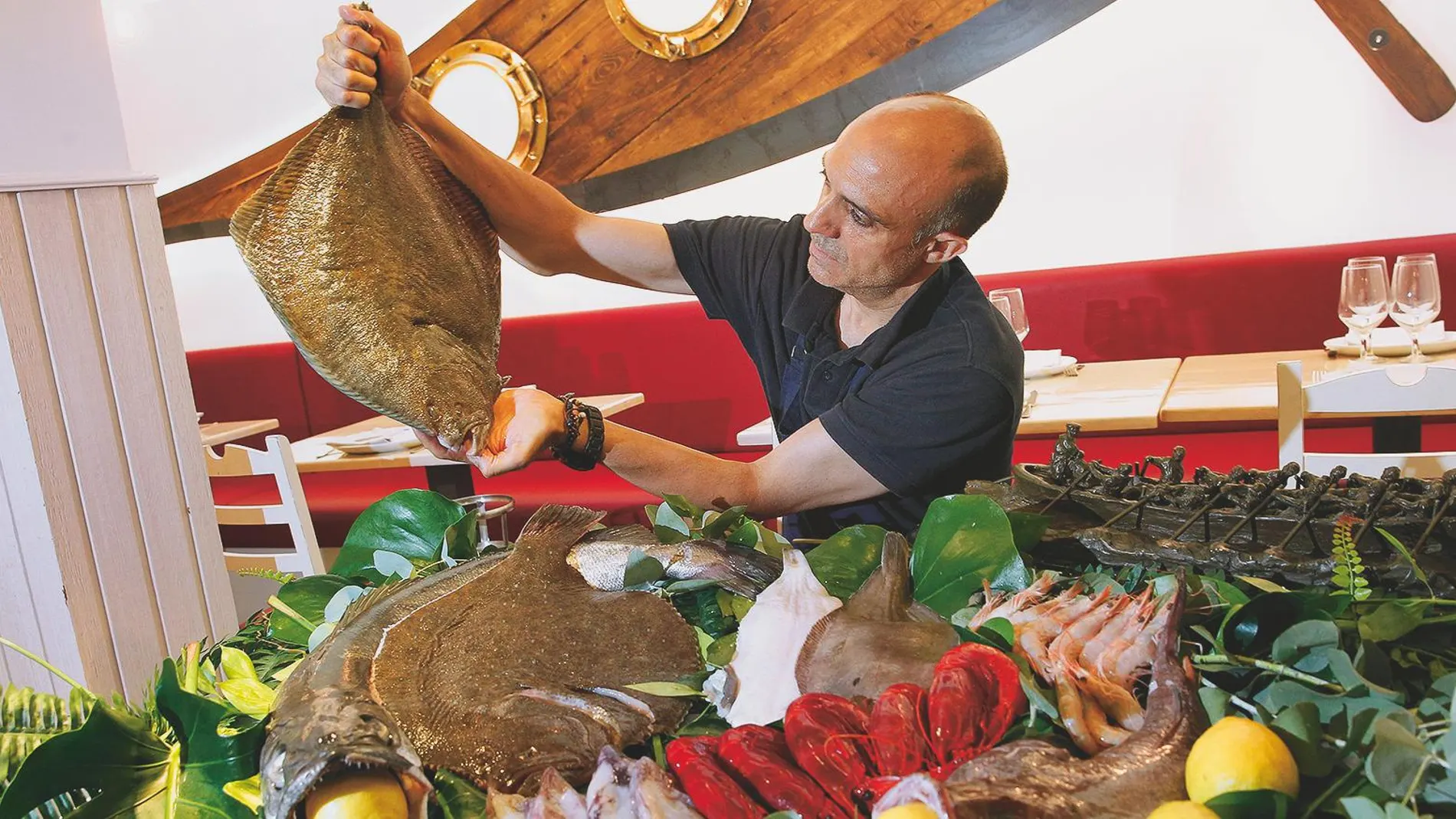 Un camarero muestra el producto con el que triunfa La Trainera: el rape, el lenguado, el rodaballo y la merluza. Foto: Connie G. Santos