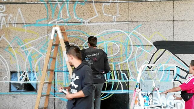 Varios jóvenes mientras pintaban la fachada del edificio