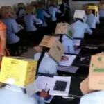 Imagen de los estudiantes con cajas en sus cabezas difundida en redes sociales.