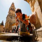 Un turista se refresca en una de las fuentes del patio de los Naranjos de la Mezquita-Catedral de Córdoba, ayer cuando las temperaturas máximas continúan en ascenso en Andalucía