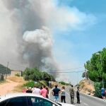 Varios vecinos observan una columna de humo en el municipio de Cenicientos