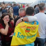 Familiares y periodistas rodean a los prisioneros liberados tras aterrizar en Kiev/Efe