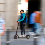 Hombre conduciendo un patinete eléctrico por la calle
