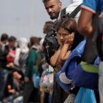 Varios inmigrantes sirios esperan un autobús tras desembarcar de un ferry en el puerto del Pireo, en una imagen de archivo/Efe