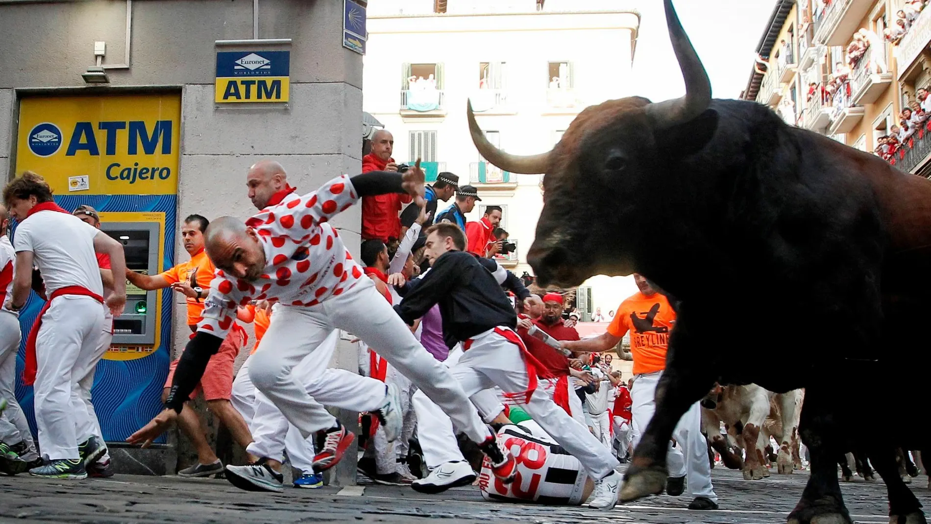 Los toros de la ganadería de La Palmosilla, de Tarifa (Cádiz), a su paso por la curva de la calle de Mercaderes, durante el séptimo encierro de los Sanfermines 2019