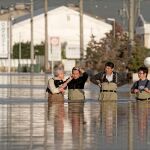 Unos trabajadores intentan salir de una zona inundada en la prefectura de Nagano, en Japón.