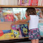 Una niña elige el próximo libro que se va a leer / Manolo Olmedo