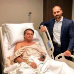 Jair Bolsonaro tras ser operado junto a su hijo Eduardo, que porta una pistola en la cintura/Twitter/@BolsonaroSP