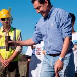 El presidente del Gobierno de Andalucía, Juanma Moreno, sujeta una planta que le ofrecieron los alumnos del IES Odón Betanzos Palacios de Mazagón (Huelva) para participar en una actividad de reforestación en la zona afectada por el incendio de 2017, dentro de los actos conmemorativos del 50 aniversario del Parque de Doñana esta semana / Foto: Efe