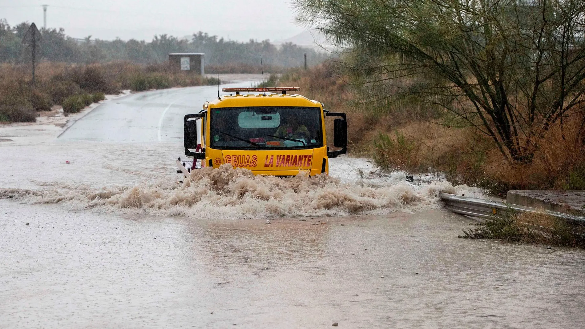 Una grúa pasa por la rambla de la Cañada Morcillo, en el polígono industrial de La Estrella en Molina de Segura. EFE/Marcial Guillén