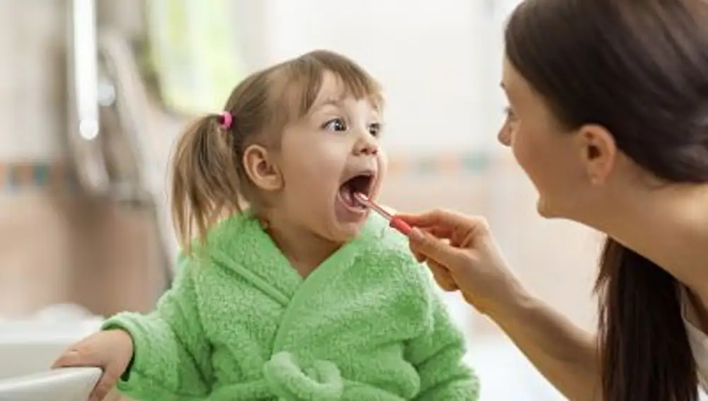 Una madre lava los dientes a su hija