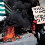 Un manifestante ante varios neumáticos ardiendo/Reuters