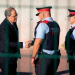 El presidente de la Generalitat, Quim Torra, saluda a dos Mossos d'Esquadra en una imagen de archivo/ep