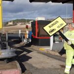Un operario retira uno de los carteles con los precios a la AP-1