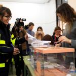 Una funcionaria de correos entrega un paquete con votos a la presidenta de una mesa el pasado domingo
