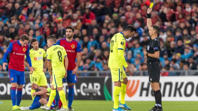 El arbitro ucraniano enseña la amarilla a Enric Gallego