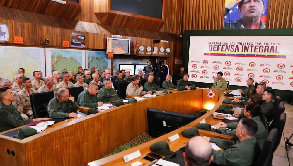 Fotografía cedida por el Palacio de Miraflores donde se observa al presidente de Venezuela Nicolás Maduro (c, atrás) en un acto de gobierno este martes en Caracas (Venezuela). Maduro informó el martes que la Milicia Bolivariana, un cuerpo conformado por civiles militantes del chavismo, será desplegada hasta el 31 de diciembre en las calles del país para "garantizar la paz y las navidades felices". EFE/PALACIO DE MIRAFLORES/