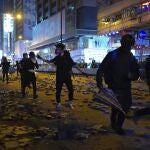 Protesters run along a street in the Kowloon area of Hong Kong, Monday, Nov. 18, 2019. As night fell in Hong Kong, police tightened a siege Monday at a university campus as hundreds of anti-government protesters trapped inside sought to escape. (AP Photo/Vincent Yu)