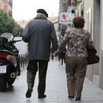 Una pareja de pensionistas pasea por la calle