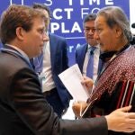 Un representante de los pueblos indígenas entrega un escrito en defensa de la Amazonia al alcalde de Madrid, José Luis Martínez-Almeida