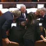 El líder de la coalición Azul y Blanco, Benny Gantz, en el centro, dialoga con otros diputados en la sesión del miércoles de la Kenesset en la que se decidió la celebración de nuevos comicios/AP