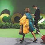 Dos participantes de la Cumbre del Clima abandonan las instalaciones de Ifema, que ayer estaba prácticamente vacío